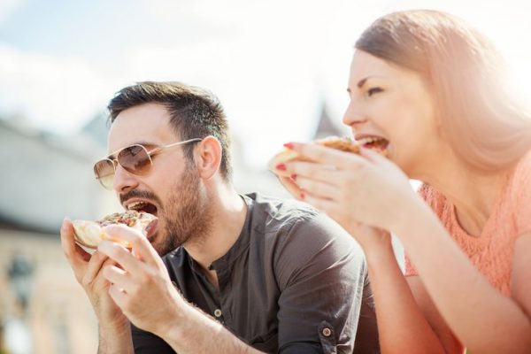 Young couple eating pizza.